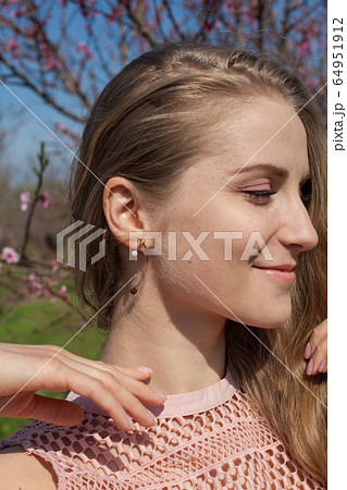 Ladybird and blonde woman in flowering garden 64951912