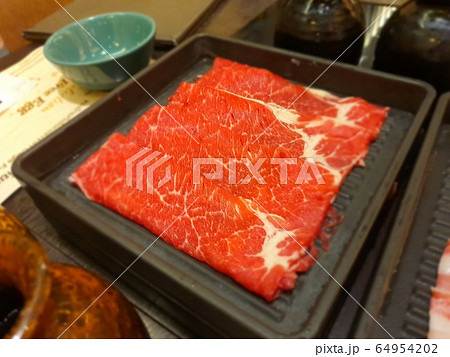 Selective focus to fresh raw beef slices for hot pot in a black plate. 64954202