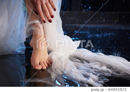 Female legs in the water with splashes. Photo in a neon light in the studio 64955972