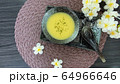 soup in a dish , spoon and flower on a table 64966646