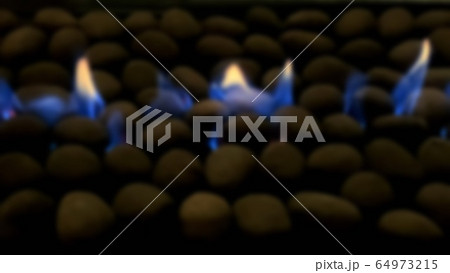 Blue gas fire roaring through small stones on the 64973215
