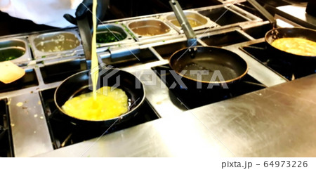 Cooking omelettes and fried eggs. Breakfast buffet Cooking omelettes and fried eggs. Breakfast buffet 64973226