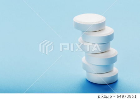 Tower of Medicinal tablets on a blue background, 64973951