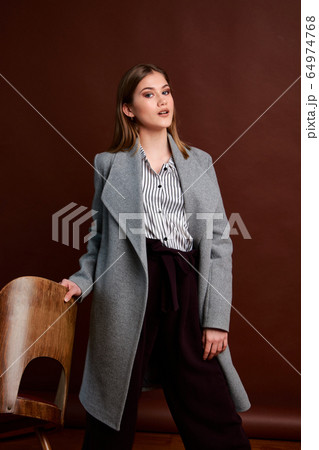 Gorgeous young female in classic suit, black shoes Gorgeous young female in classic suit, black shoes 64974768