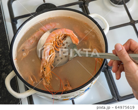 Cooking large fresh prawns in a bowl.  64975619