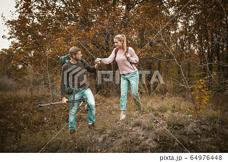 Man Supports His Woman To Go Down The Hill 64976448
