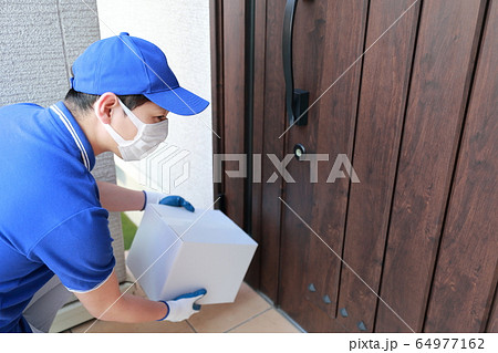 置き配 対面なし (作業員 男性 仕事 30代 ビジネスマン 人物 配達員 宅配員 段ボール 玄関) 64977162