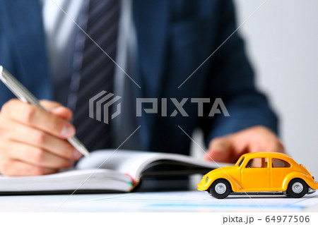 Unrecognizable yellow toy car on selling documents 64977506