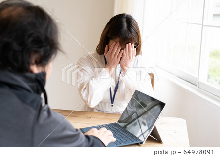 おじさんに怒られる女性 64978091