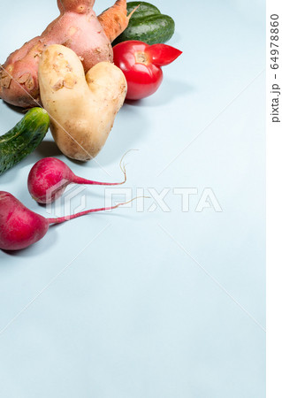 Ripe ugly vegetables: potatoes, tomato, cucumbers and radishes on light blue background. Waste zero concept. Image with copy space. Ripe ugly vegetables: potatoes, tomato, cucumbers and radishes on light blue background. Waste zero concept. Image with copy space. 64978860