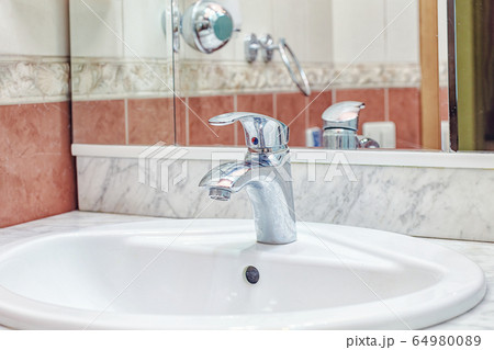 Simple cheap Faucet in bathroom white sink Simple cheap Faucet in bathroom white sink 64980089