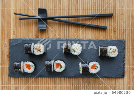 Sushi on a black stone board. Fresh sushi set with Sushi on a black stone board. Fresh sushi set with 64980280