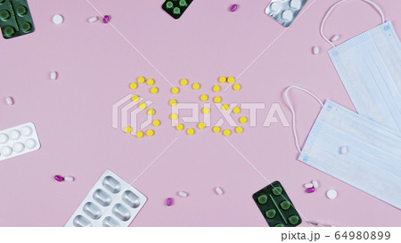 Protective medicine mask, thermometer and pills on 64980899