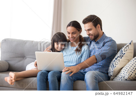 Happy family with kid daughter enjoy using laptop at home Happy family with kid daughter enjoy using laptop at home 64982147