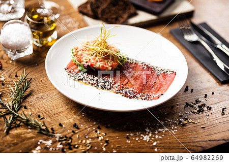 Tuna sashimi on white plate. Delicious healthy Japan traditional snacks seafood closup served on a table for lunch in modern gourmet restaurant. Tuna sashimi on white plate. Delicious healthy Japan traditional snacks seafood closup served on a table for lunch in modern gourmet restaurant. 64982269