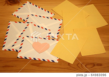 木のテーブルにエアメール封筒と黄色の便箋 airmails and yellow letters 木のテーブルにエアメール封筒と黄色の便箋 airmails and yellow letters 64983096