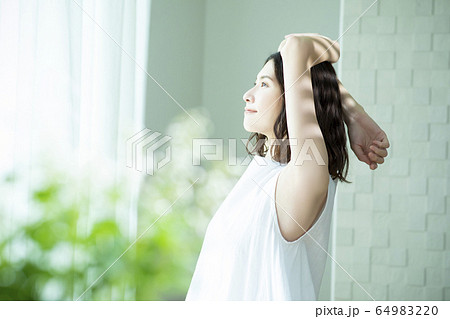 伸びをする女性 伸びをする女性 64983220