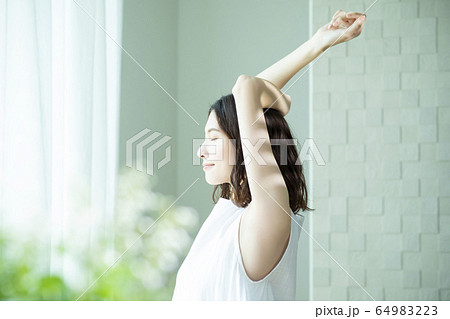 伸びをする女性 伸びをする女性 64983223
