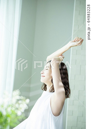 伸びをする女性 伸びをする女性 64983228