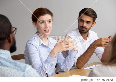 Confident female leader speak at group training explain corporate strategy Confident female leader speak at group training explain corporate strategy 64983978