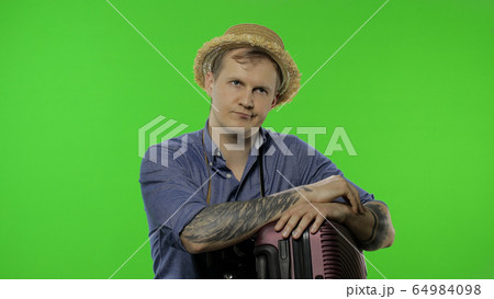 Portrait of exhausted man tourist photographer shows dissatisfaction. Chroma key 64984098
