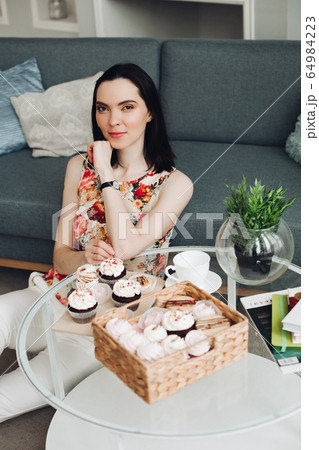 Handsome young woman sits on a floor and thinks Handsome young woman sits on a floor and thinks 64984223