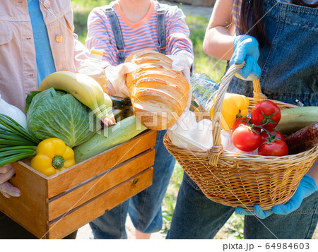 Food package for the needy in the period of the pandemic coronavirus in the hands of volunteers. Close-up of food packages for the poor. 64984603