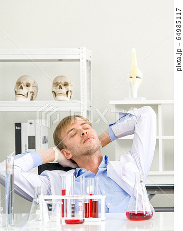 Young scientist rested his eyes and neck after completing his research. Young scientist rested his eyes and neck after completing his research. 64985117
