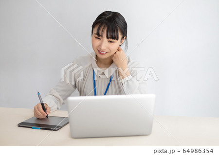 ペンタブレットを操作する女性 ペンタブレットを操作する女性 64986354