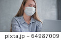 Young Caucasian doctor woman working from home online using laptop, consulting people on quarantine wearing face mask. 64987009