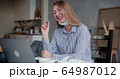 Young beautiful happy blonde woman using laptop to chat with friends on video call from home with her face mask off. 64987012