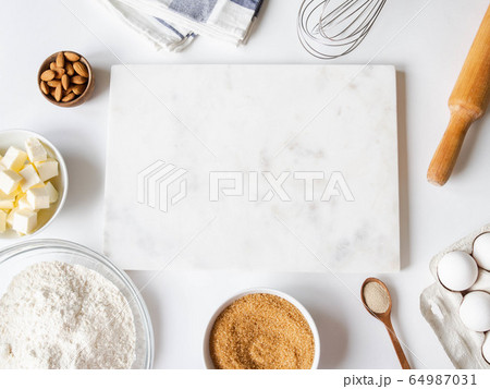 Frame of various baking ingredients,  kitchen utensils and white marble  board. 64987031