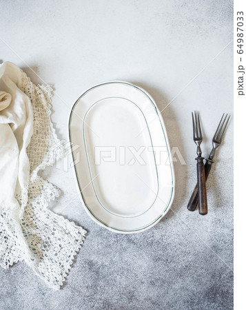 Vintage  table setting with oval plate, white  lace napkin and forks 64987033