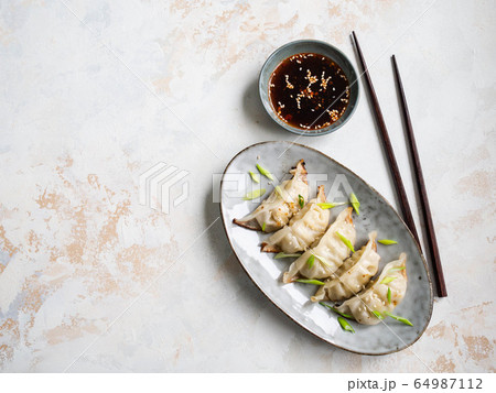 Chinese traditional dumplings - gyoza with pork and vegetables on an oval plate with soy sauce i Chinese traditional dumplings - gyoza with pork and vegetables on an oval plate with soy sauce i 64987112