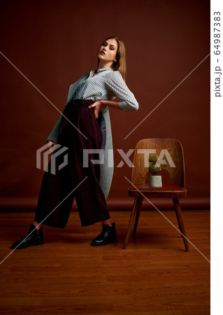 Gorgeous young female in classic suit, black shoes 64987383