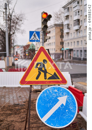 road signs Roadworks ahead and Pass on this side 64988142