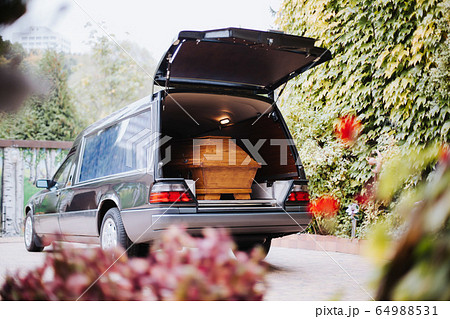 a coffin in the back of a car at a funeral a coffin in the back of a car at a funeral 64988531