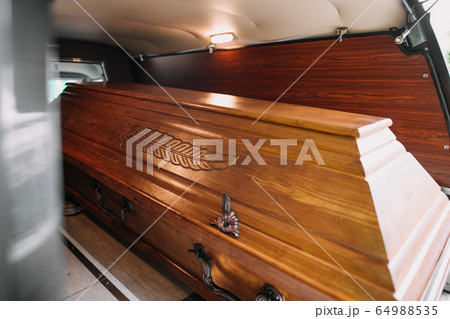 a coffin in the back of a car at a funeral a coffin in the back of a car at a funeral 64988535