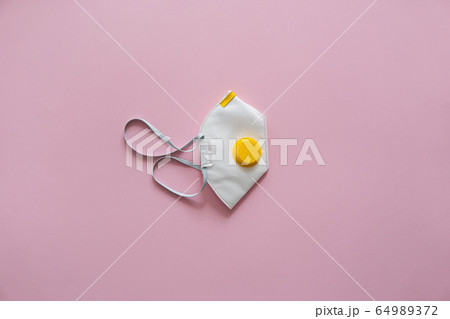 Respirator mask FFP or dust mask to cover the mouth and nose prevent coronavirus isolated on pink background. Breathing protection against air pollution, flu and coronavirus. 64989372