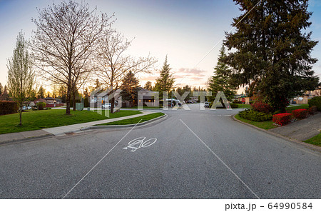 Residential Suburban Neighborhood in the City during a vibrant springtime sunset. Residential Suburban Neighborhood in the City during a vibrant springtime sunset. 64990584