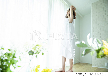 伸びをする女性 伸びをする女性 64992439