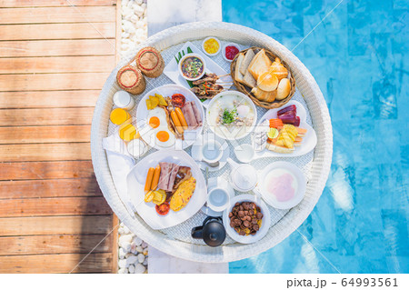 Floating breakfast set in tray with fried egg omelette sausage ham bread fruit milk juice coffee Floating breakfast set in tray with fried egg omelette sausage ham bread fruit milk juice coffee 64993561