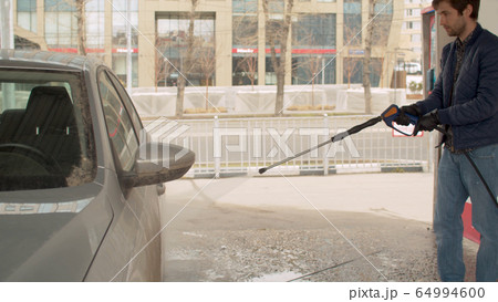 Handsome man washing car 64994600