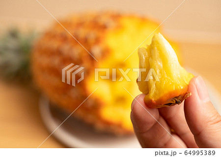 パイナップル（スナックパイン）を持つ男性の手 64995389