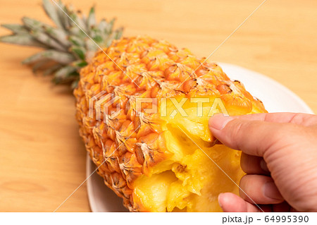 パイナップル（スナックパイン）を持つ男性の手 64995390