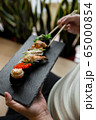 Assorted fresh sushi gunkan maki with seafood. set of gunkans in hands. Selective focus. 65000854