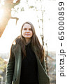 young beautiful woman in park posing for photographer 65000859
