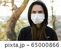 Close up of woman wearing protective face mask. Coronavirus covid-19 outbreak prevention concept. 65000866