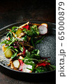 Healthy salad of fresh vegetables - tomatoes, avocado, arugula, radish and seeds on a bowl. Vegan food. Close up 65000879