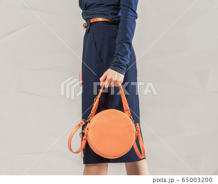 Stylish fashionable woman with orange round bag 65003200